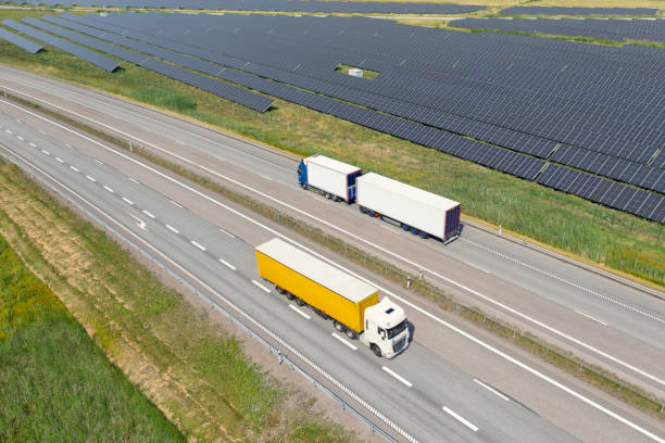 istock Trucks on the highway next to a solar power installation 1445272466