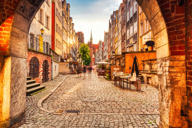 Célèbre rue Mariacka dans une lumière dorée avec la basilique Sainte-Marie en arrière-plan, Gdansk - Photo