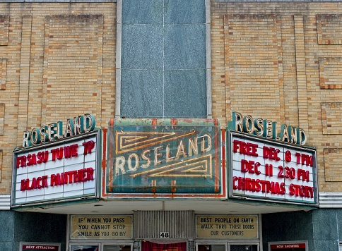 Fargo, ND, USA - July 24, 2015: People walking underneath the foyer canopy of the famous Fargo theater with it's overhead sign on N. Broadway Dr in downtown Fargo, North Dakota