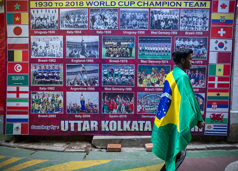 World Cup football result history poster is also available in Kolkata Street. One Brazilian supporter is having a look when he is passing the poster.