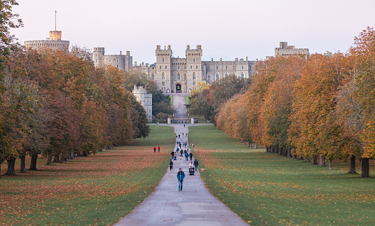 Windsor, England, UK - November 22, 2021.  Pedestrians on the Long Walk outside of Windsor Castle at sunset.