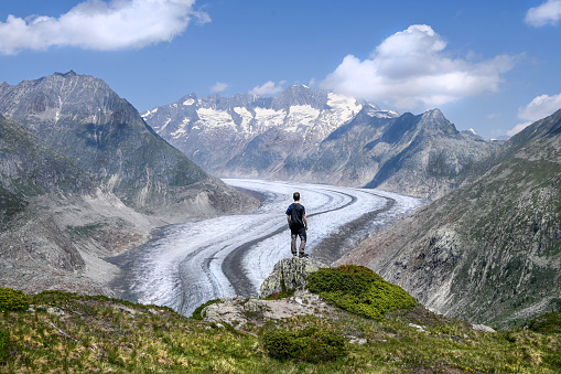A man is looking down on Altsch glacier in the alps on a sunny day