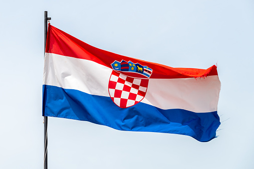 A croatian flag on a pole waving in the wind
