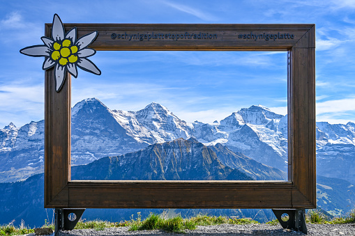 Wooden frame with a view on the mountain range Eiger Moench and Jungfrau in the Swiss alps on a sunny day