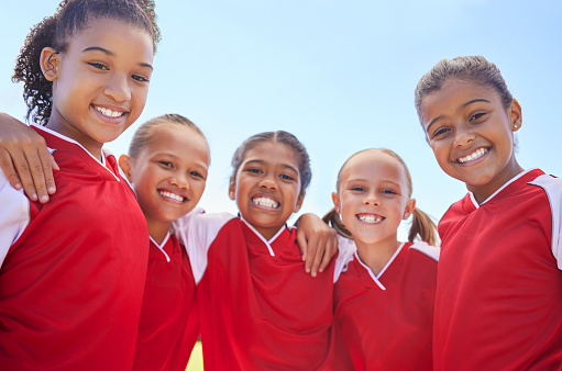 Girl team, in soccer and happy with teamwork and team building at stadium. Friends, diversity and collaboration in sports motivation for fitness, bonding, exercise and training. Smile in portrait.