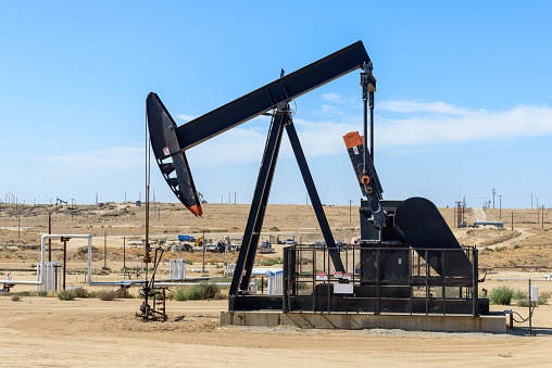 Close up of a pumpjack in a oil field in California on a clear autumn day. Bakersfield, CA, USA.