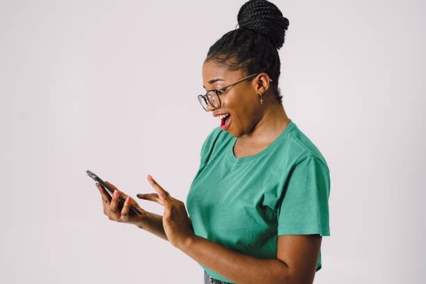 istock Surprised beautiful African American woman using smartphone smiling and standing 1445289621