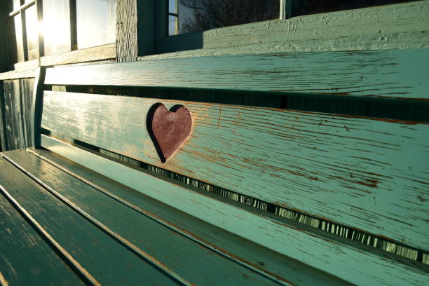 Wooden bench carved with a heart shape.