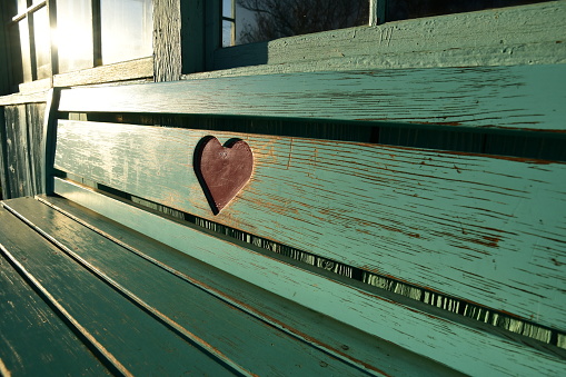 Wooden bench carved with a heart shape.