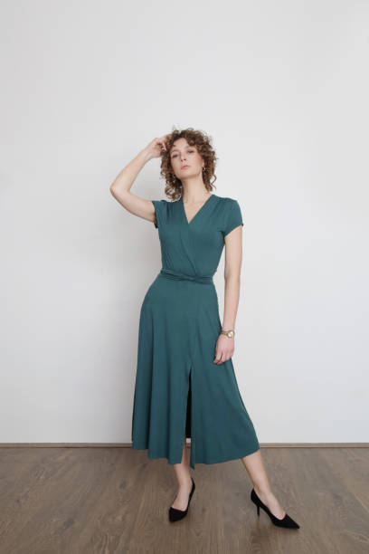 Serie of studio photos of young female model in green viscose wrap dress. Serie of studio photos of young female model in green viscose wrap dress. wrap dress stock pictures, royalty-free photos & images