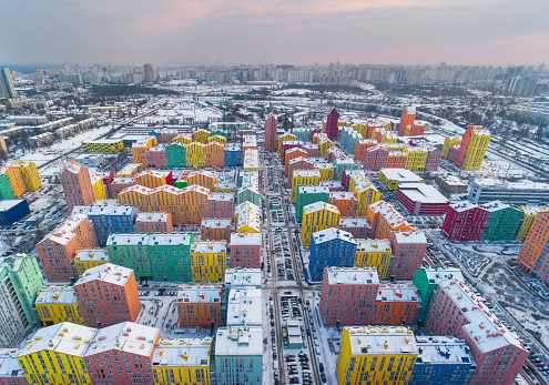 Snow-covered colored Kyiv residential buildings from the air. View from the left bank to the right