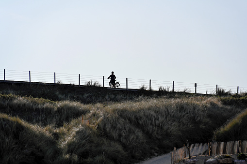 Erquy, France, September 20, 2022 - Silhouette of a cyclist on a cliff of Cap d'Erquy