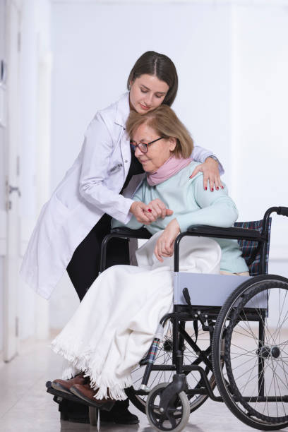 istock caring nurse and elderly patient hugging 1445308174