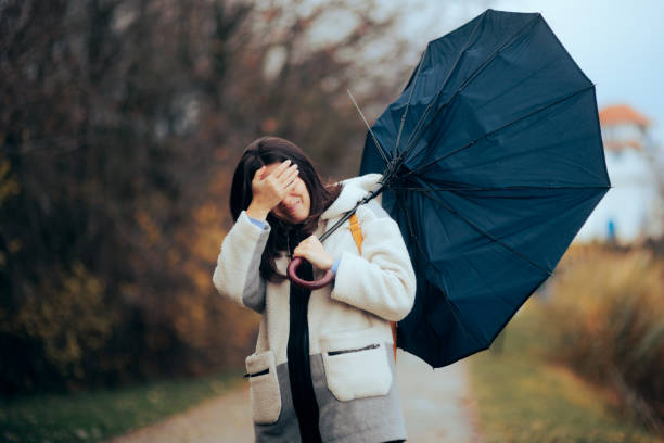 istock Woman with Broken Umbrella Walking in a Storm 1445310971