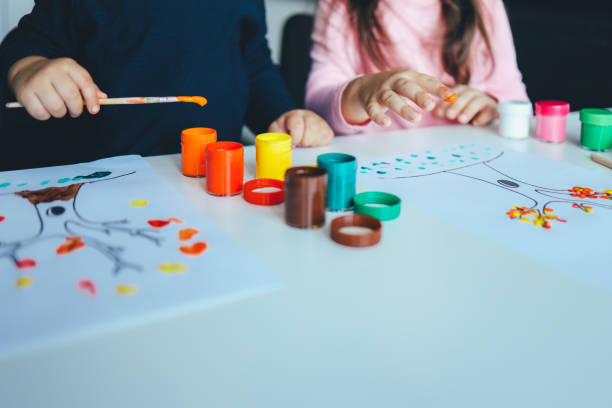 istock Children draw trees with leaves with colorful paints. Creative activities 1445317443