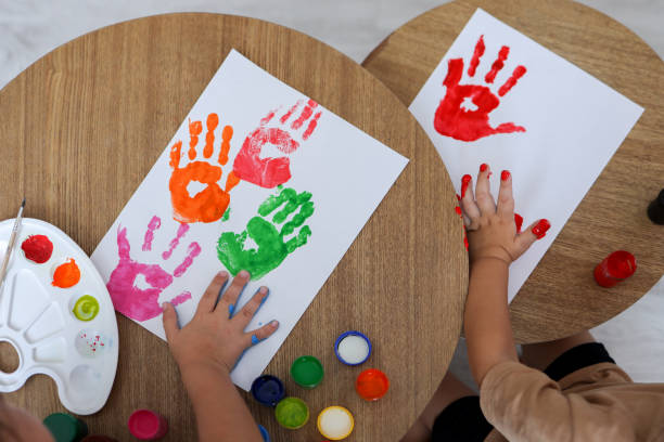 istock Children's drawing workshop, happy children make handprints with paint 1445317447