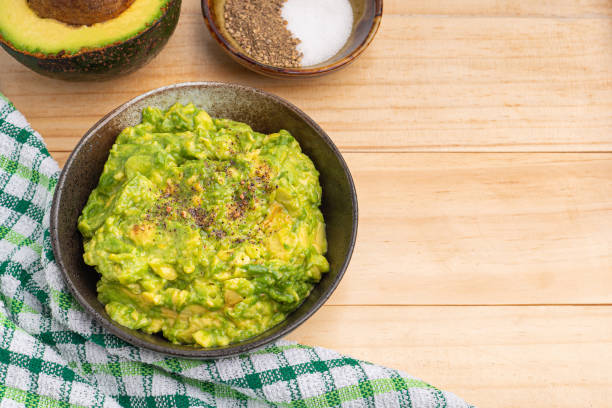istock Fresh guacamole on a dish with ingredients for homemade guacamole 1445323039
