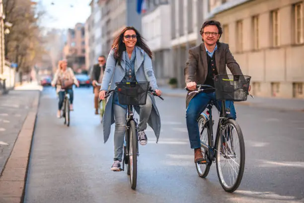 Going to work on a bike leads to a healthy lifestyle. Active male and female commuting.