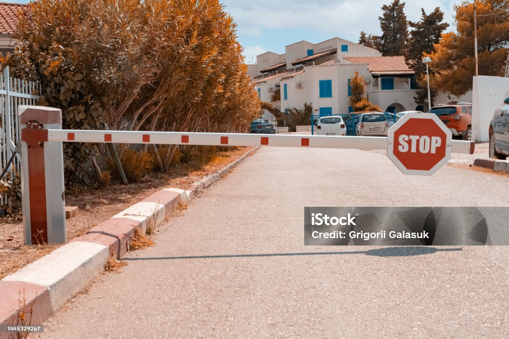 a barrier with a round stop sign protecting the private area from suspicious people. Fencing for the entry of cars into a closed protected area. Accessibility Stock Photo a barrier with a round stop sign protecting the private area from suspicious people. Fencing for the entry of cars into a closed protected area. Accessibility Stock Photo