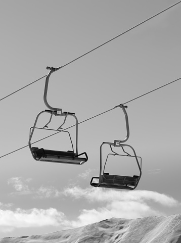 Chair lifts and snowy winter high mountains. Caucasus Mountains, Georgia, region Gudauri. Black and white toned image.