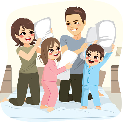 Happy sweet family making pillow fight over bed on bedroom having fun