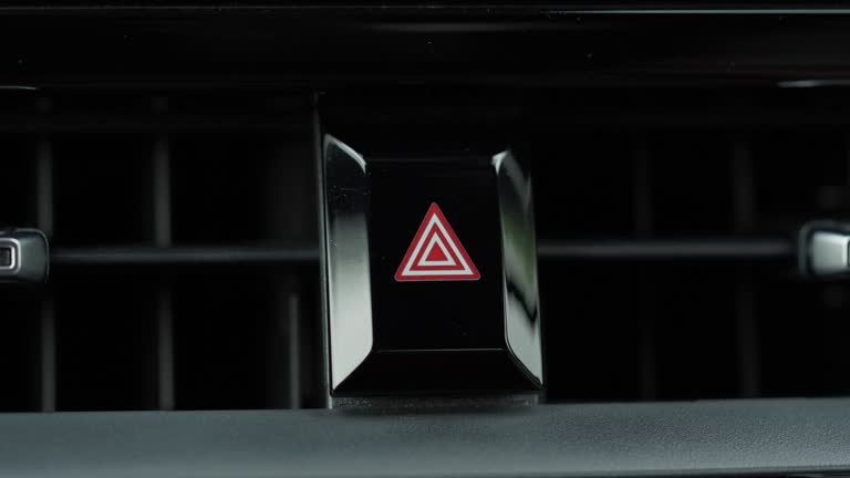 Close-up of index finger pushing a passenger car hazard light button on a vehicle dashboard. Accident emergency sign and situation