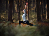 Female athlete stretching her body in autumn day at the forest.