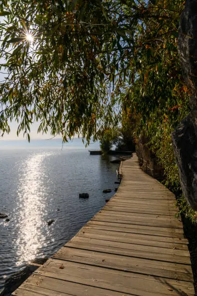 wooden boardwalk leading along the shores of the clear blue waters of Lake Ohrid