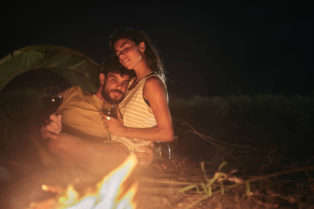 istock Loving couple drinking wine on camping night at the beach. 1445343487