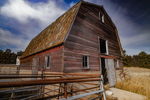 A low angle shot of an old barn on an abandoned farmstead in the Nebraska Sandhills