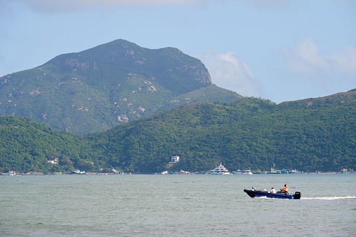 A boat sailing in Waterfall Bay, Hong Kong on a sunny day