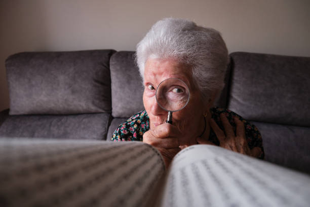 older woman looking through a magnifying glass