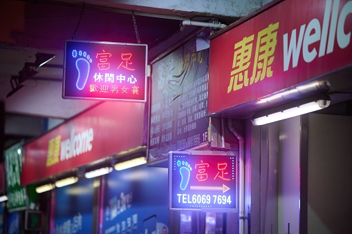 Hong Kong, Hong Kong – June 02, 2022: colorful illuminating Neon light signs on the street in Kowloon City, Hong Kong at night