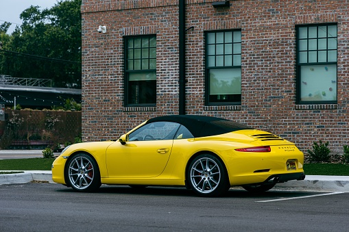 Saint Petersburg, United States – June 05, 2022: A side view of a modern yellow Porsche 911 GT3 sportscar parked on the road