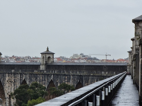 Lisbon, Portugal – April 21, 2022: A view of the old run-down Lisbon aqueduct with urban city background