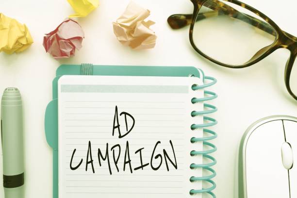 istock Illustration of glasses, crumpled papers, mouse, pen and a notebook with ad campaign text on it 1445355810