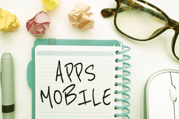 istock Illustration of glasses, crumpled papers, mouse, pen and a notebook with apps mobile text on it 1445355818
