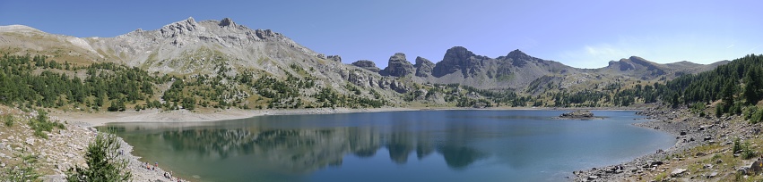 A panorama of a lake with hills under the clear blue sky