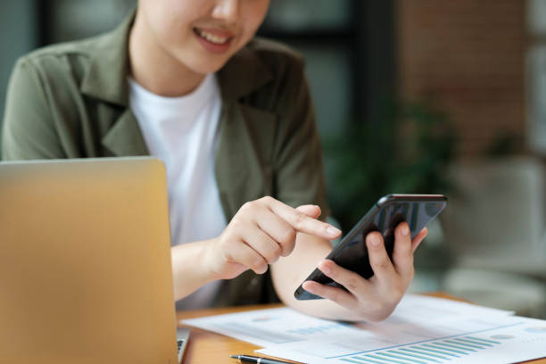 istock Young asian businesswoman working at office using mobile phone. 1445358401