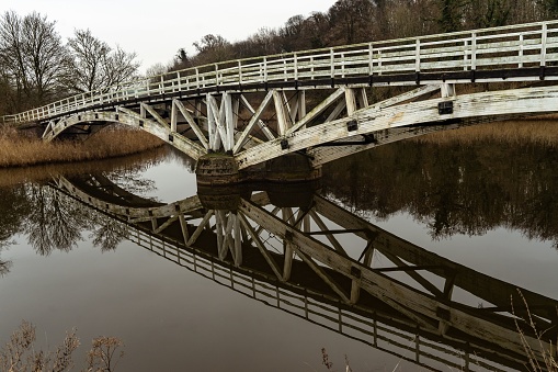 A scenic view of the Dutton Horse Bridge reflecting on a river in in Cheshire, England