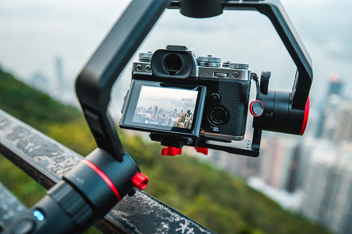 Image of an aerial view of Hong Kong city on a camera, held by stabilizator.