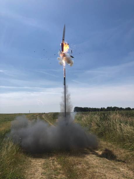 istock Vertical shot of a rocket flying from a green field to a cloudy sky 1445362568
