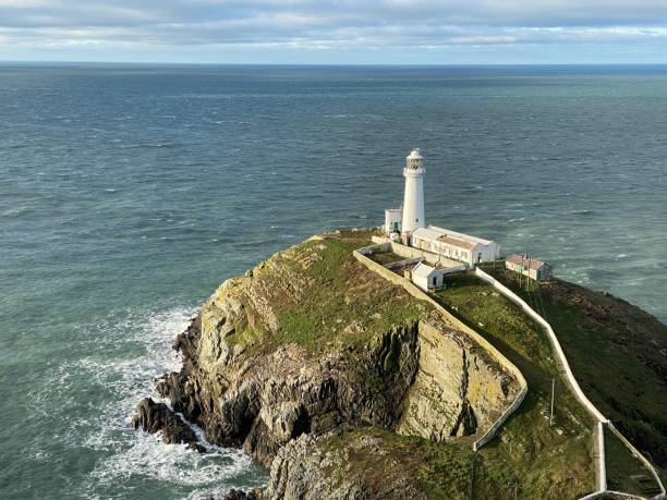 istock Aerial view of a lighthouse on a cliff covered with greenery against a sea 1445362913