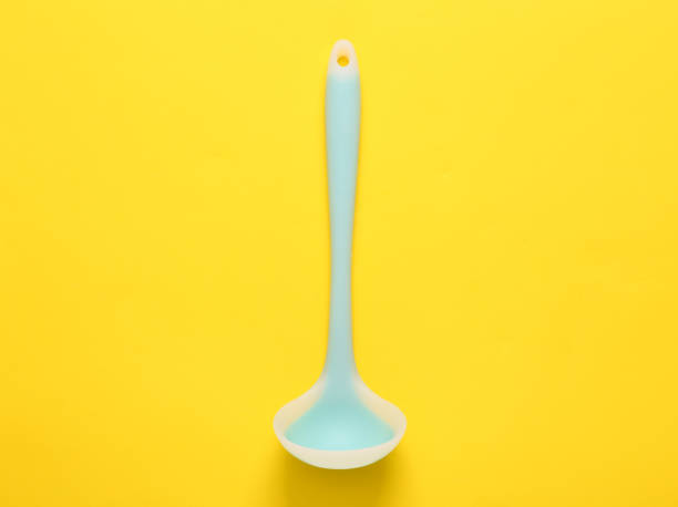 istock Silicone ladle on a yellow background. Top view 1445363561