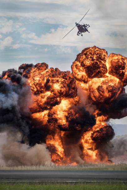 istock Vertical shot of an attack helicopter flying over an explosion 1445363777