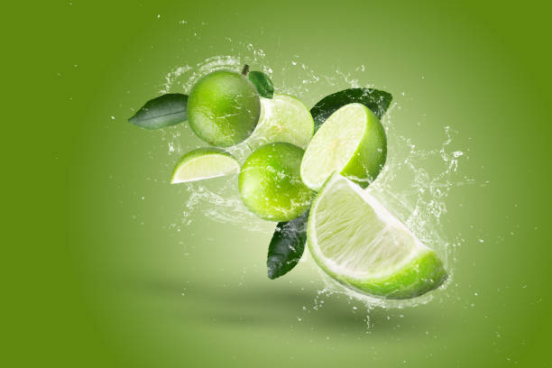istock lemonade Splashing on Green lemon fruit isolated on Green background 1445363933