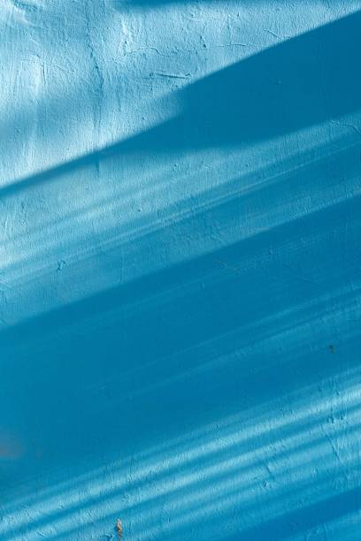 istock Vertical shot of a blue wall under sunlight. 1445363941