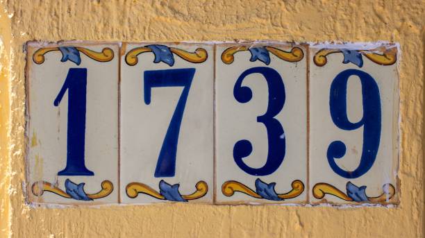 istock Old Ceramic Tile Numbered Address in Mexico. Blue Font, Yellow Wall 1445365818
