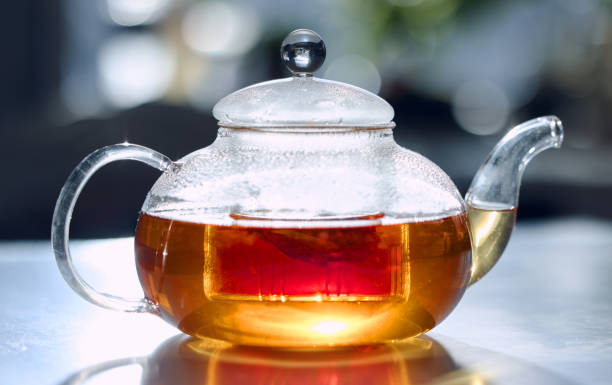istock Tea, drink and fresh with a bag in a glass pot for drinking, refreshment or brewing on a table in the kitchen. Herbal, health and natural with an organic beverage to boost your immune system 1445366378