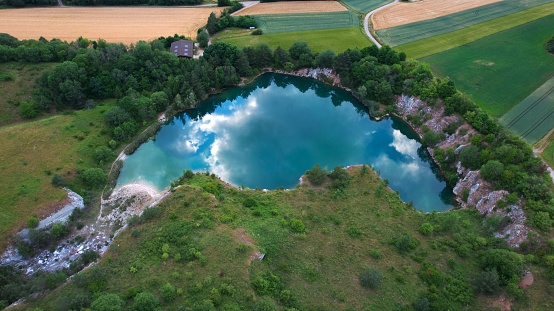 An aerial view of a lake surrounded by green plant fields in Germany